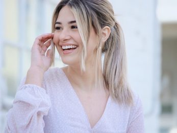 woman in white v neck long sleeve shirt smiling