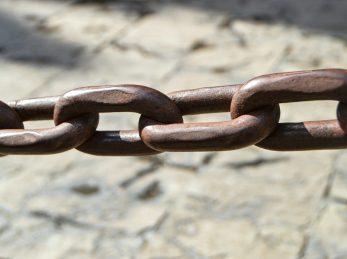 a close up of a metal chain on a stone surface